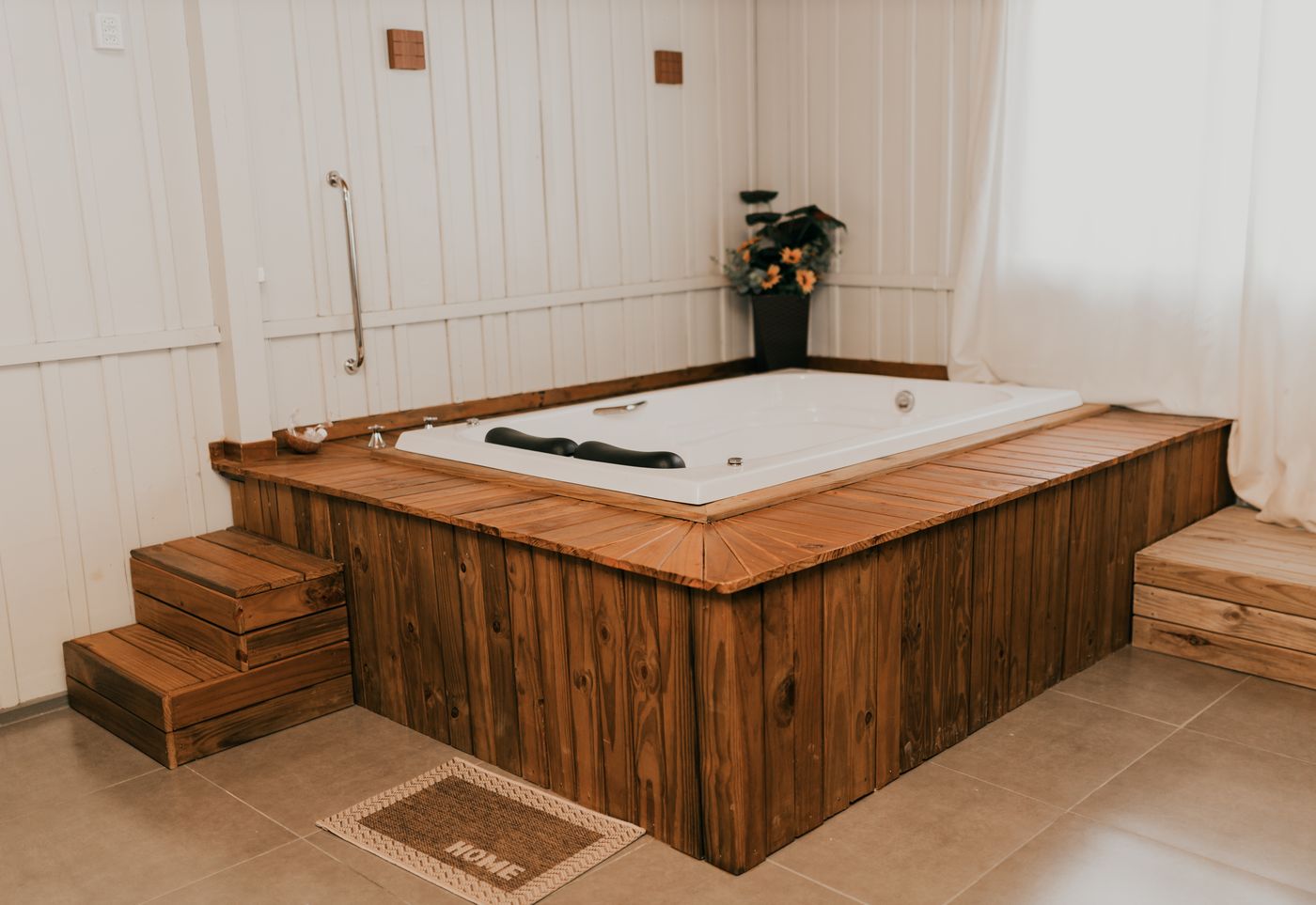 Banheira de hidromassagem embutida no deck de madeira na cabana Girassol