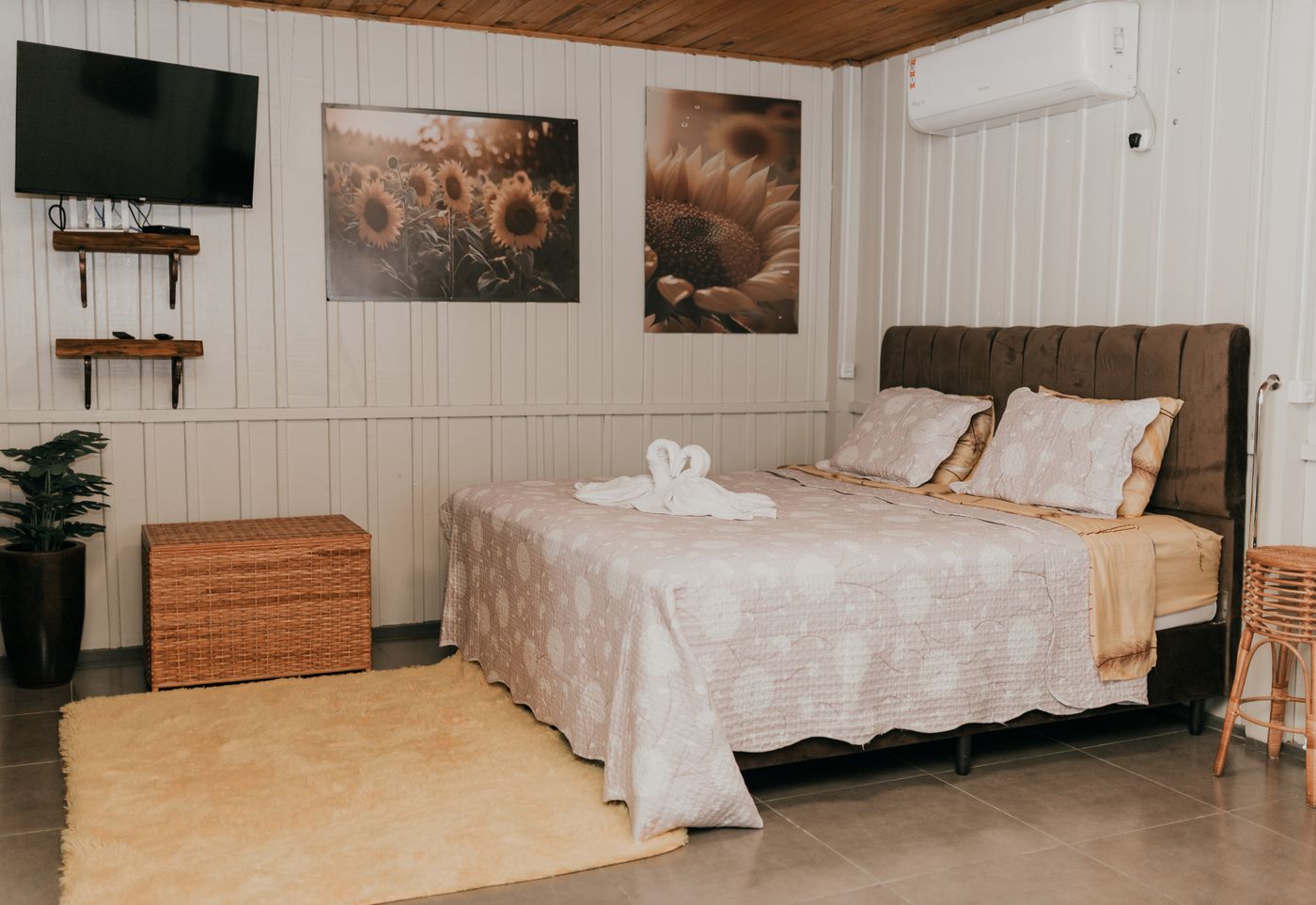 Quarto da cabana Girassol com quadros de girassol e tapete claro