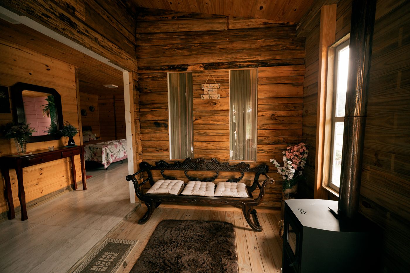 Sala de estar da cabana Lavanda com banco entalhado e espelhos