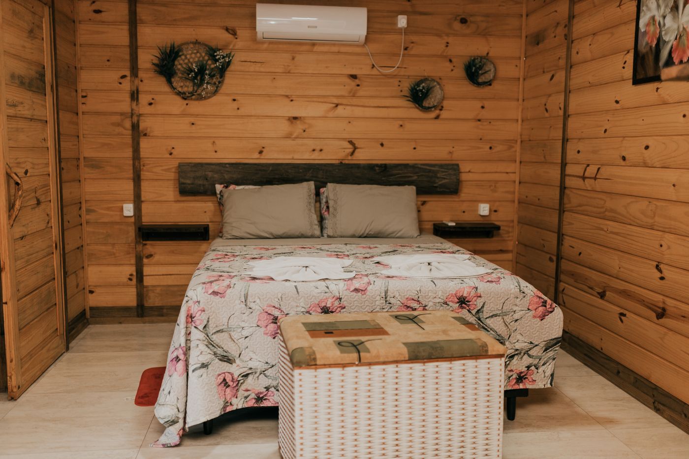 Quarto de casal com colcha floral na cabana Lavanda