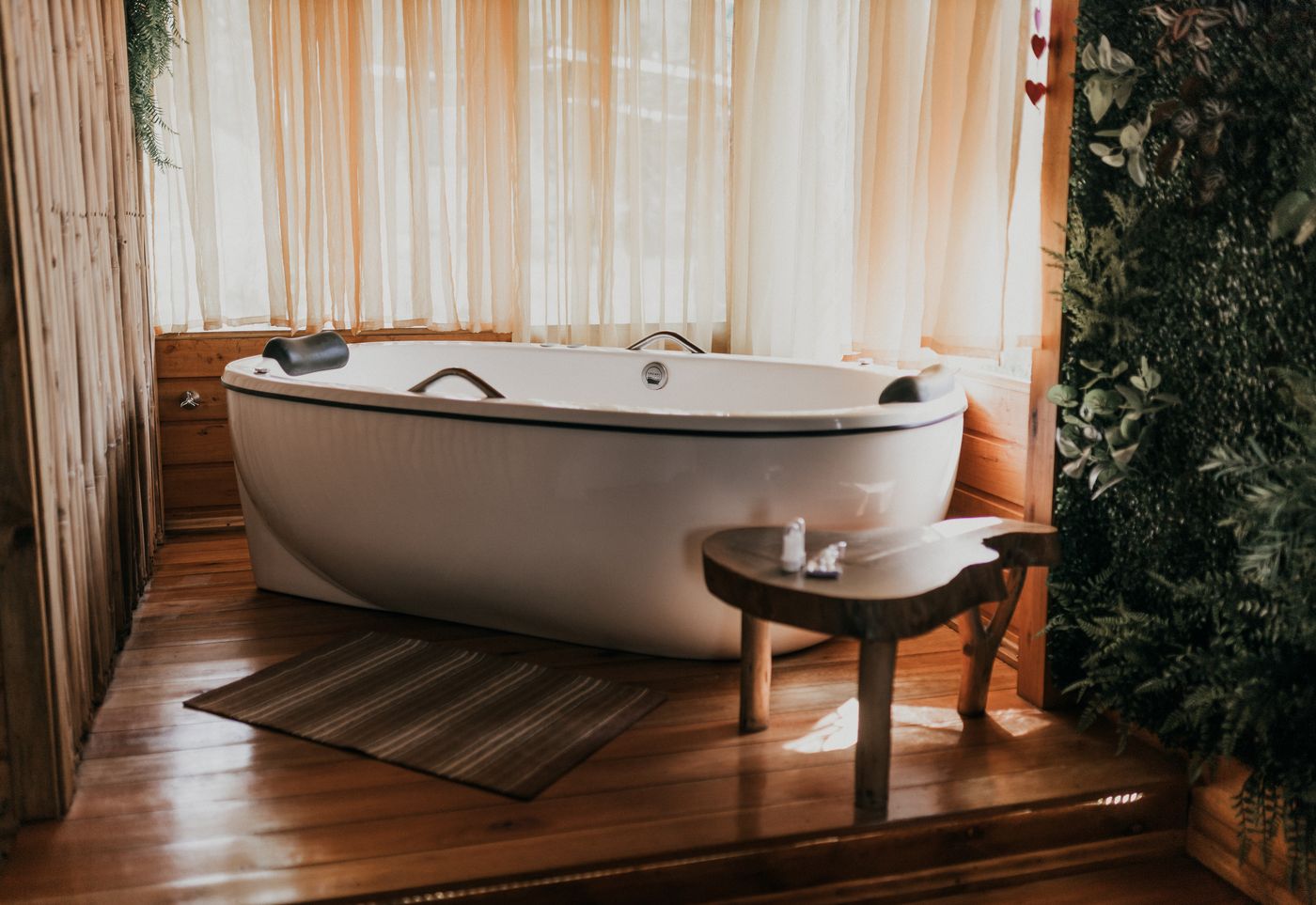 Banheira de hidromassagem entre plantas na cabana Patchouli
