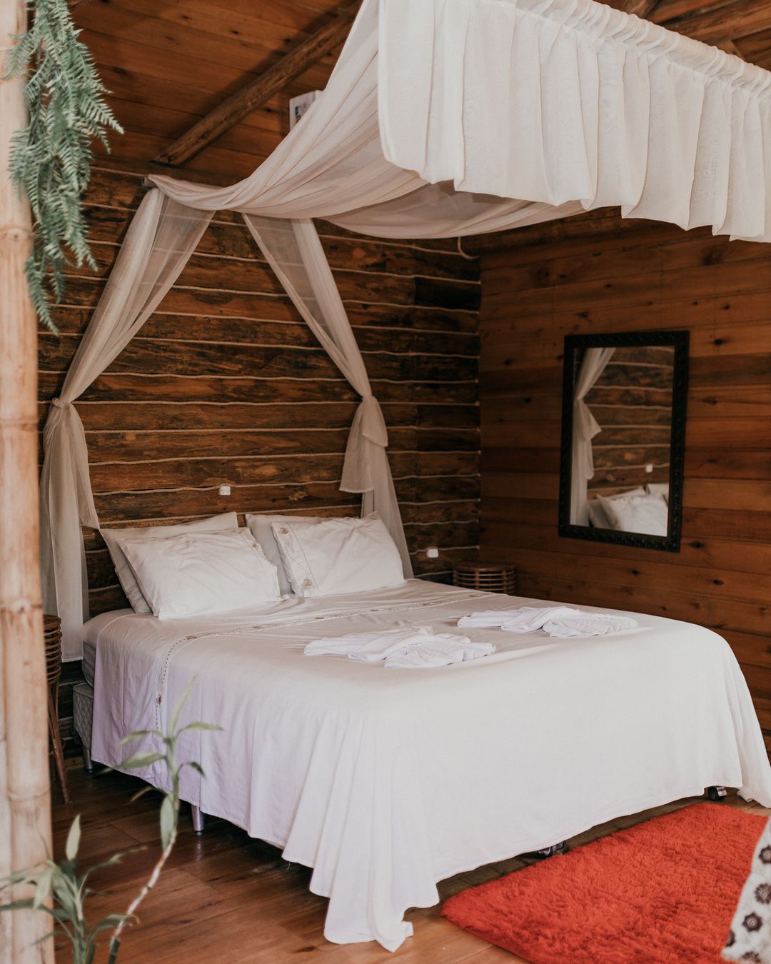 Cama de casal com dossel de voil na cabana Patchouli