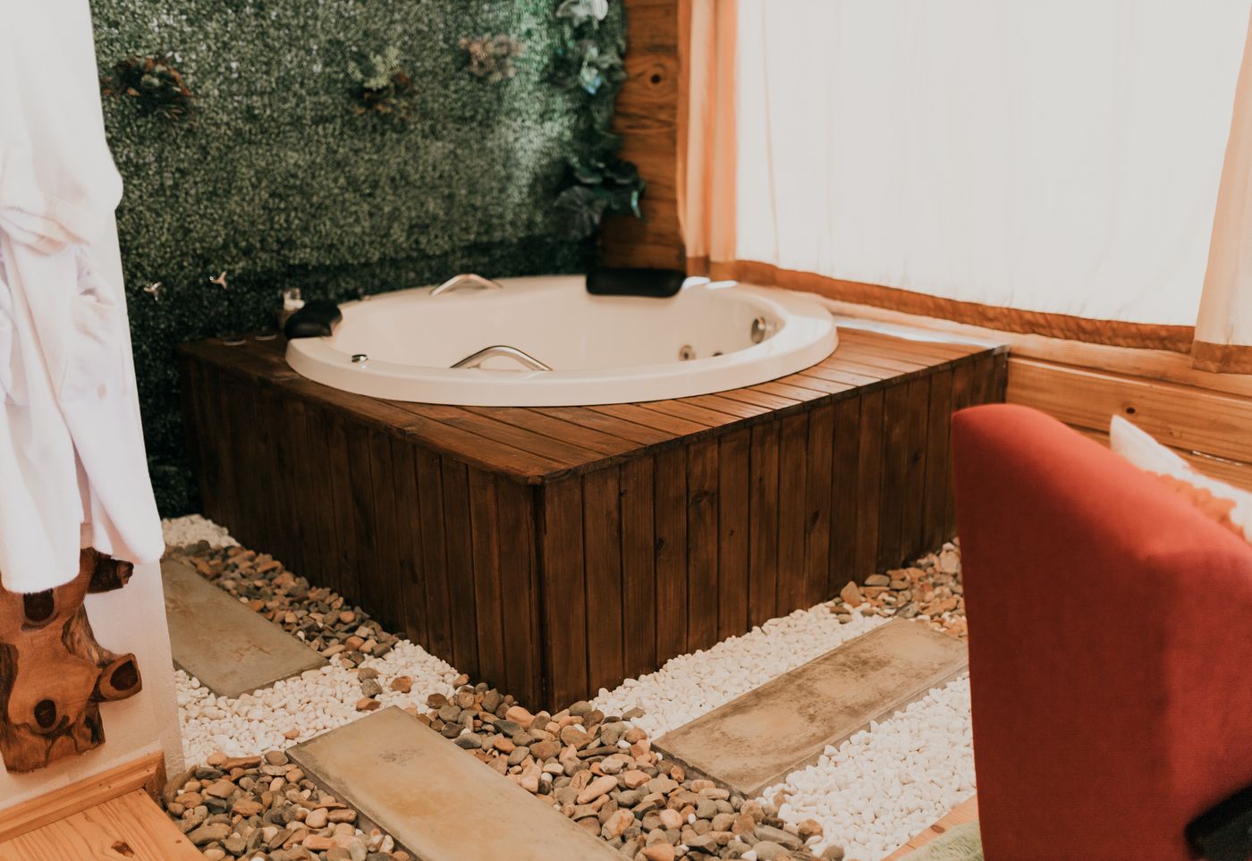 Banheira de hidromassagem com parede de plantas na cabana Ylang Ylang
