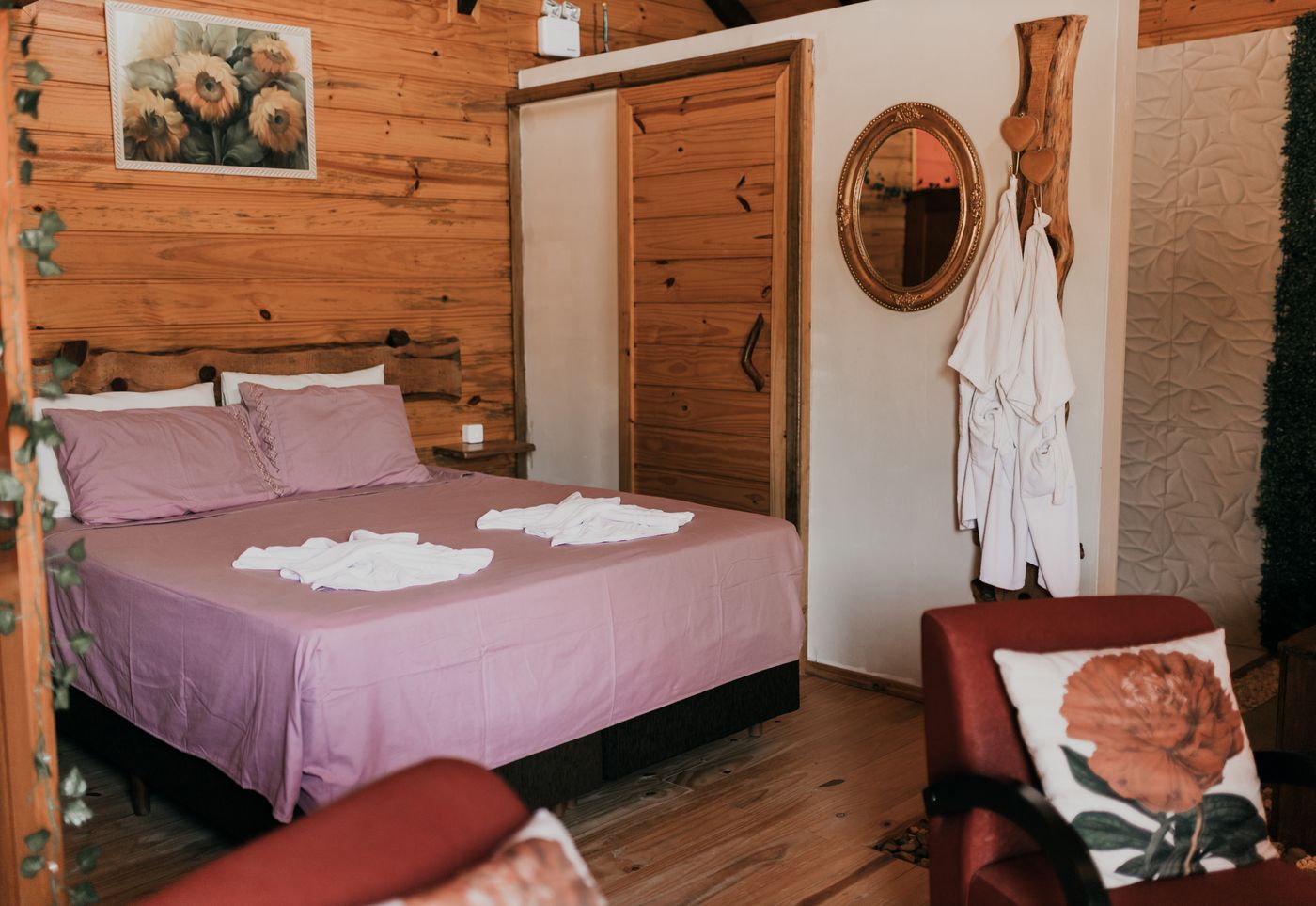 Quarto de casal com roupa de cama rosé na cabana Ylang Ylang
